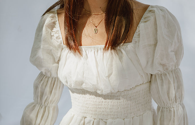 Mädchen im weißen Kleid mit silberner Halskette / Rüschenkleidung