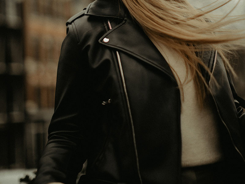 fashionable woman in hat looking away | leather bomber jacket