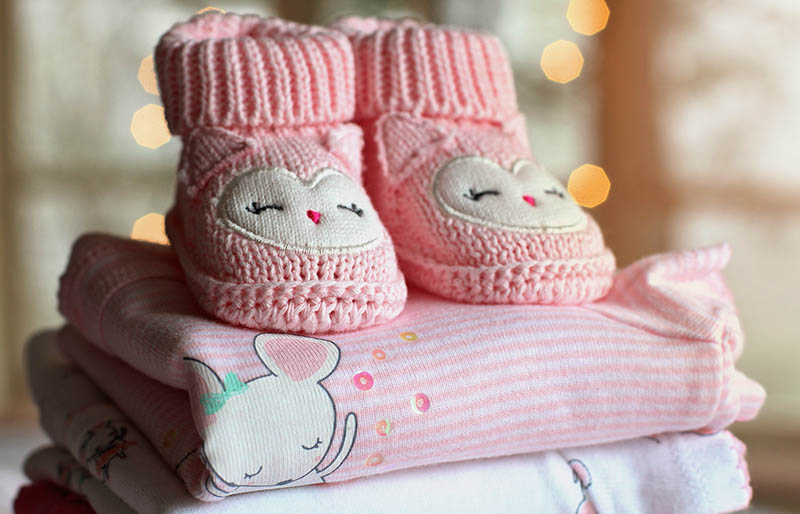pink knit cap on white textile | winter clothes for newborn