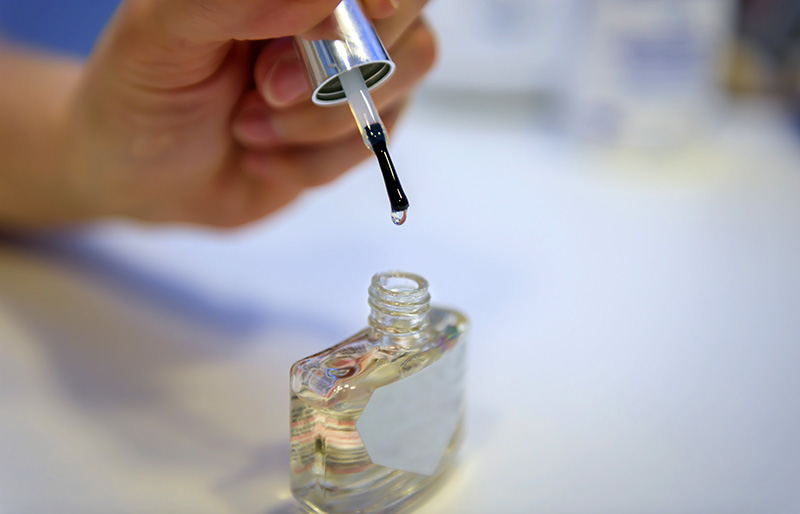 female hand holding transparent nail polish | sewing hacks