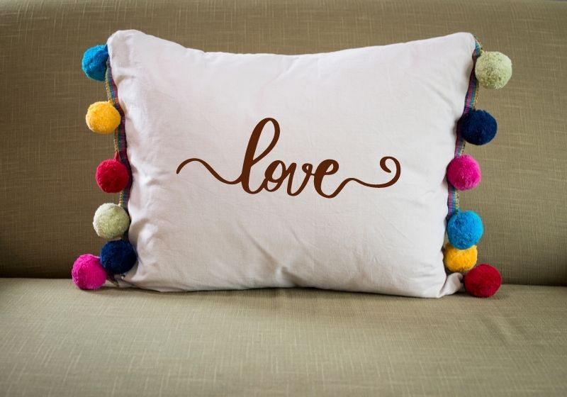 Front View of White Pillow with Colorful Pompoms on Sides | rectangle throw pillow covers