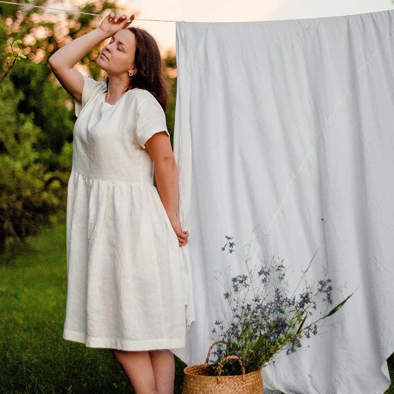 woman in white dress standing on green grass field | easy sewing projects for beginners