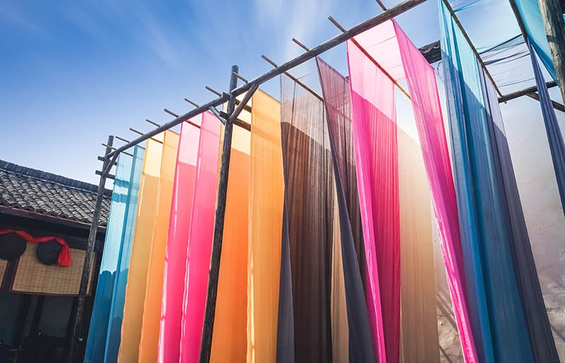 colorful fabric hanging dry after traditional | fabric stash management