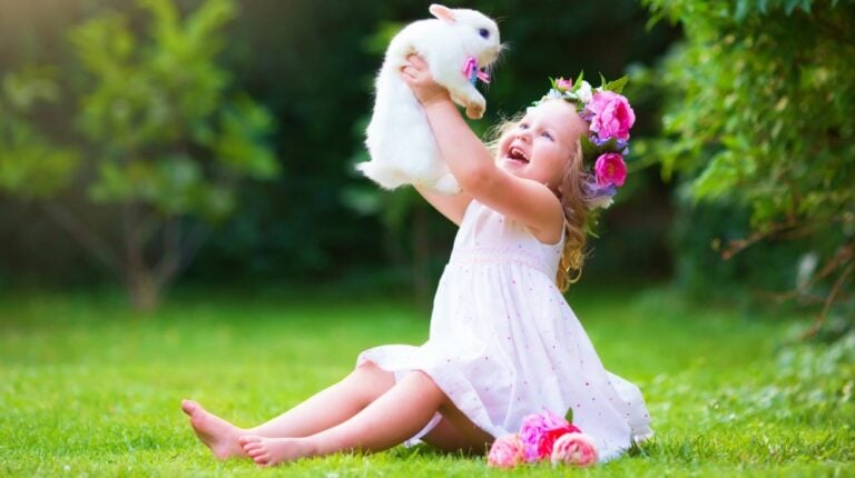 Girl playing with real rabbit in sunny garden | Easter Dresses For Girls | Free Patterns You Can Use For Sewing | kid easter dresses | Featured