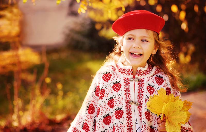 happy fashion little girl wearing bonnet | knitted poncho