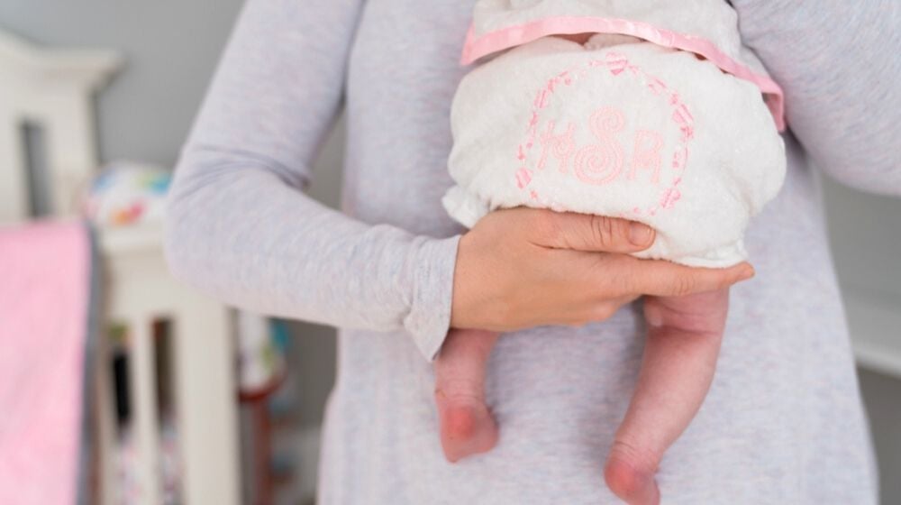 mom holding newborn baby monogrammed diaper cover | Cool Sewing Projects You Can Put Up For Sale At The Next Craft Show