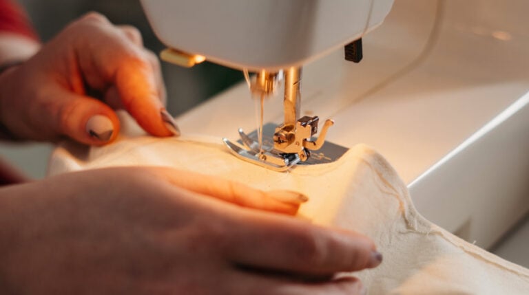 person using a sewing machine | Gusset Sewing Tutorial For Adding Extra Room To Tight Clothes | Featured