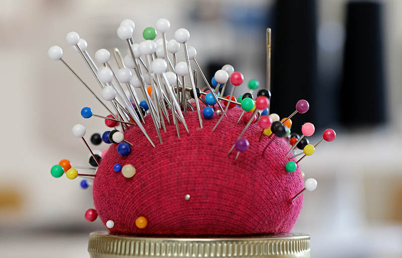 red pin cushion closeup needles pins | sewing hacks