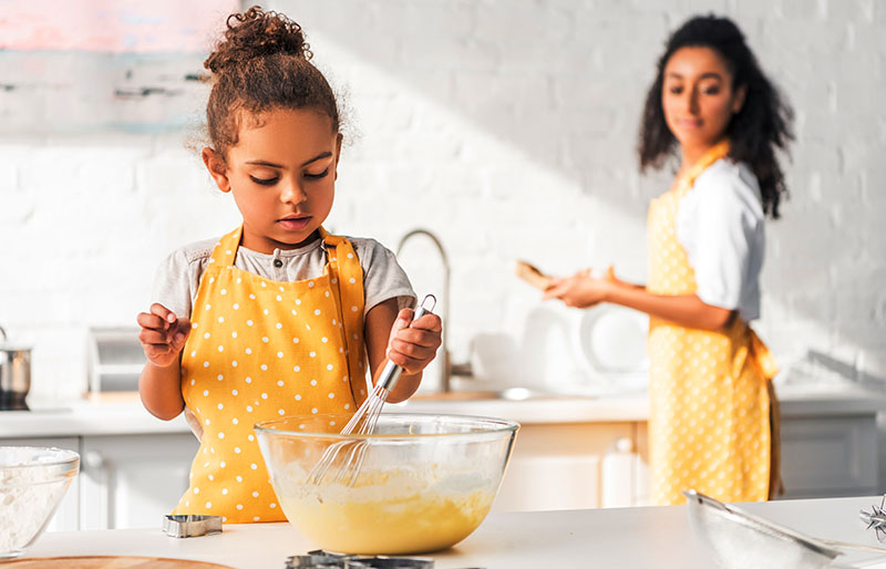selective focus african american daughter preparing | apron pattern
