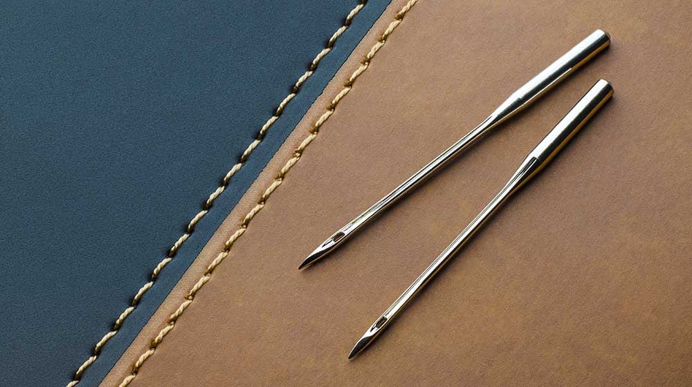 sewing machine needles leather on dark | Sewing 101 | The Basics of Sewing Leather | Featured