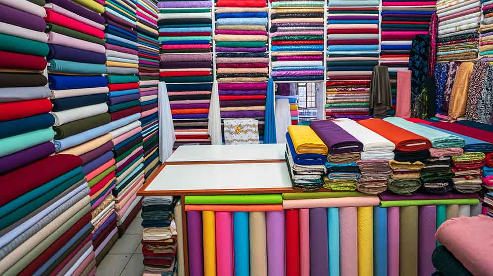 shelf wide selection colorful fabrics ribbons | Sewing Room Organization Ideas: 11 Brilliant Ways to Store Fabric | Featured