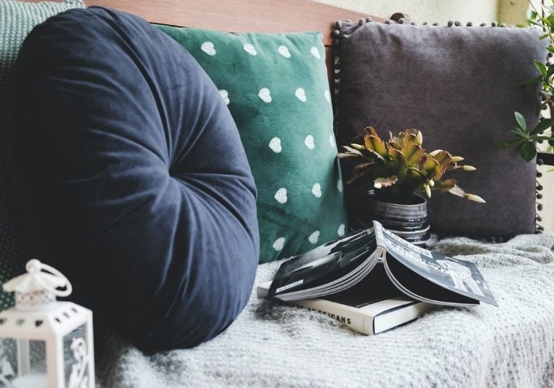 two books beside three assorted-color pillows | best throw pillow