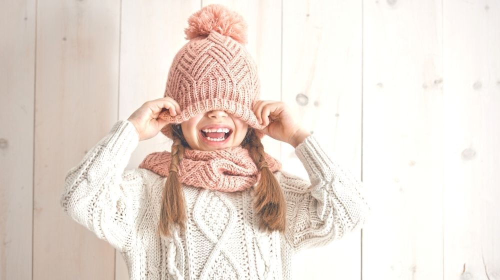 winter portrait happy little girl wearing knitted hat | Fun Sewing Ideas For Moms and Kids