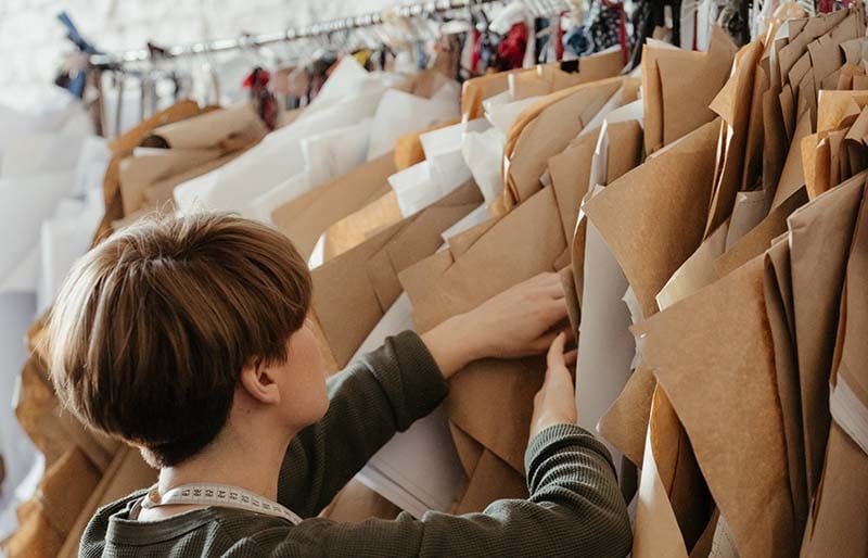 woman in gray long sleeve shirt holding brown paper bags | basic sewing skills