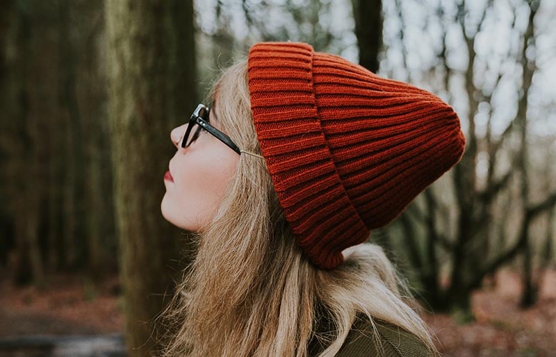woman in red knit cap and brown sweater | winter trends